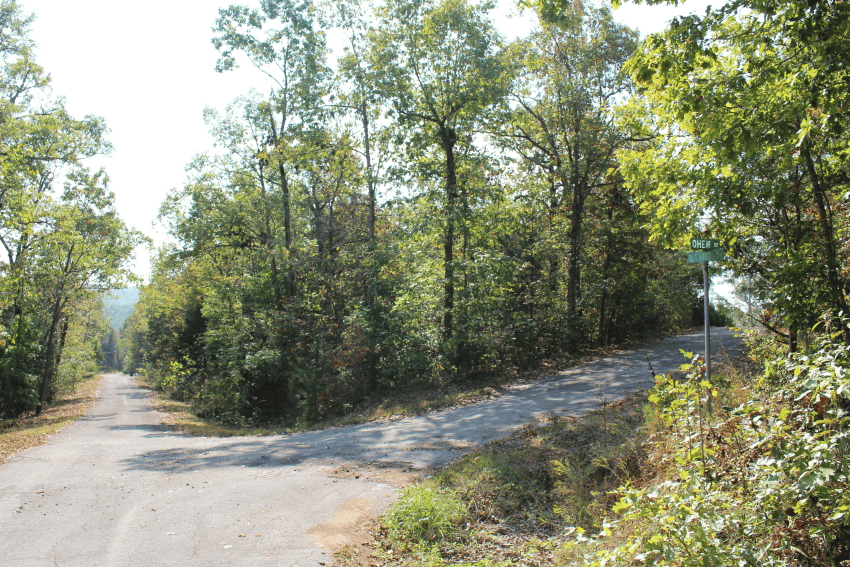 Aerial view of Cherokee Village lot 35 in Fulton County, Arkansas, showing surrounding trees, open land, and nearby utilities.