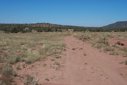 Aerial view of Arizona Navajo County 1.17-acre ranch lot 806 in Golden Horse subdivision, with open land and surrounding landscape.