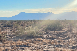 Aerial view of New Mexico Luna County 5-acre Akela Flats Lot 7, Unit 1, showing open land and surrounding terrain.