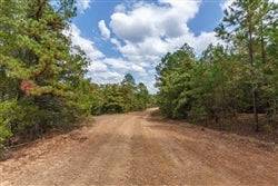 Aerial view of Oklahoma Latimer County 5.14-acre stone bridge lot with a stream, showcasing natural landscape and property features.