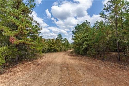 Aerial view of Oklahoma Latimer County 13.18-acre lot with stone bridge, showcasing natural landscape and property boundaries.