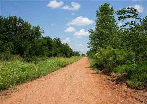 Aerial view of Oklahoma Deep Fork Ranch Lot 26 in Okfuskee County, featuring open land and rural terrain.