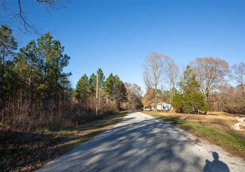 Aerial view of Whetstone Pines Lot 1 in Decatur County, Tennessee, showing wooded land, a stream, and electrical access.