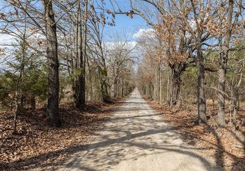 Aerial view of Wishing Star Ranch Lot 10 in Red River County, Texas, showcasing open land with surrounding trees and rural landscape.
