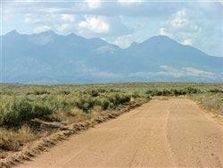 Aerial view of a 5-acre Colorado San Luis Valley property in Costilla County, with open land and distant mountains.