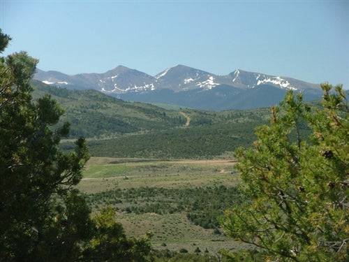 Aerial view of Eagle Ridge Ranch in Costilla County, Colorado, showcasing expansive 76.55-acre land with mountain and open fields.