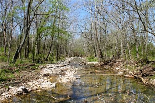Aerial view of Cedar Ridge Ranch in Phelps County, Missouri, showing 5.1 acres of wooded land with a creek and natural landscape.