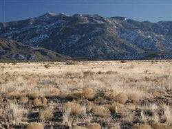 Aerial view of New Mexico Valencia County .25-acre Rio Del Oro land parcel, showcasing desert landscape and open terrain.