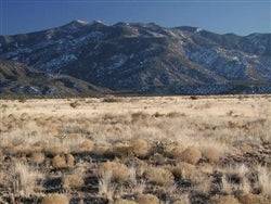 Aerial view of New Mexico Valencia County Rio Del Oro .25 acre land parcel, featuring open desert landscape and surrounding natural terrain.
