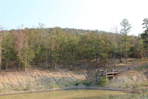 Aerial view of a 6.83-acre lake view ranch in Pushmataha County, Oklahoma, featuring lush land and scenic water surroundings.