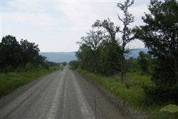 Aerial view of a 5-acre mountain view ranch lot in Pushmataha County, Oklahoma, with wooded surroundings and open land.