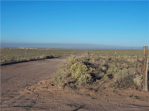 Aerial view of Navajo County Arizona Rancho Lot 75, 1.25 acres of land for sale in Arizona, with natural desert landscape and open sky.