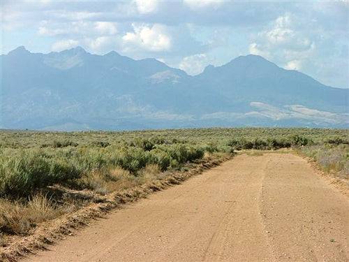 A scenic view of Colorado's Costilla County 5-acre San Luis Valley ranch land with open landscape and clear sky.